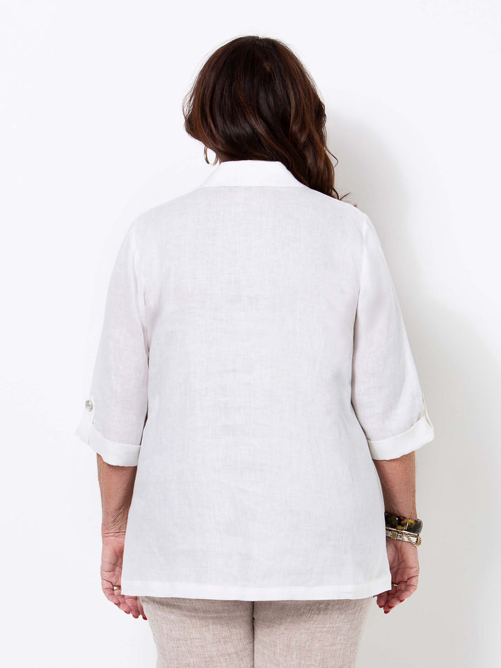 A woman viewed from the back wearing a white linen shirt with three-quarter sleeves 
