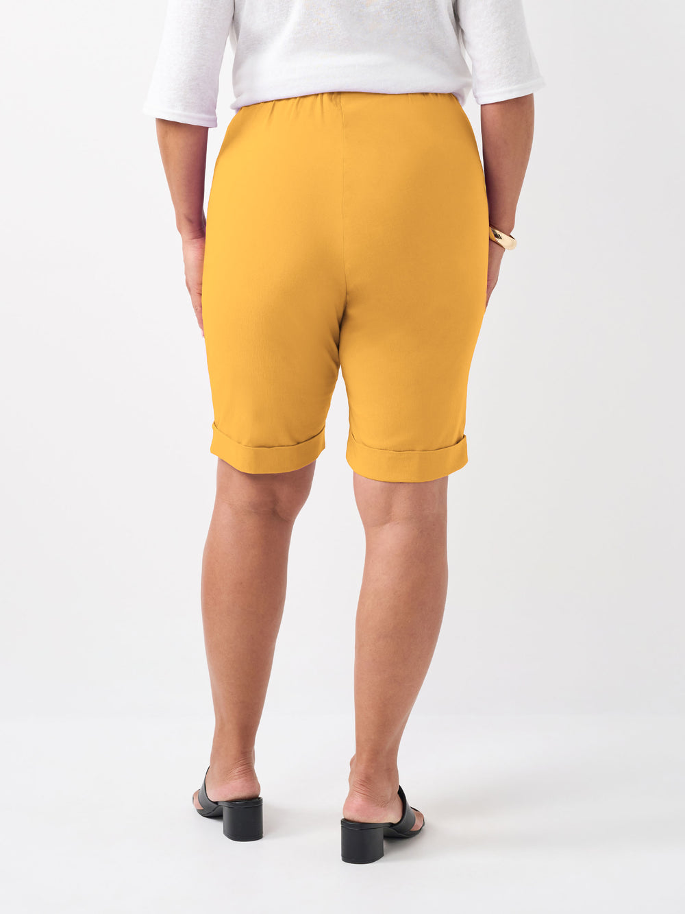 A person wearing a knee length bengaline knee length shorts in vibrant banana yellow 