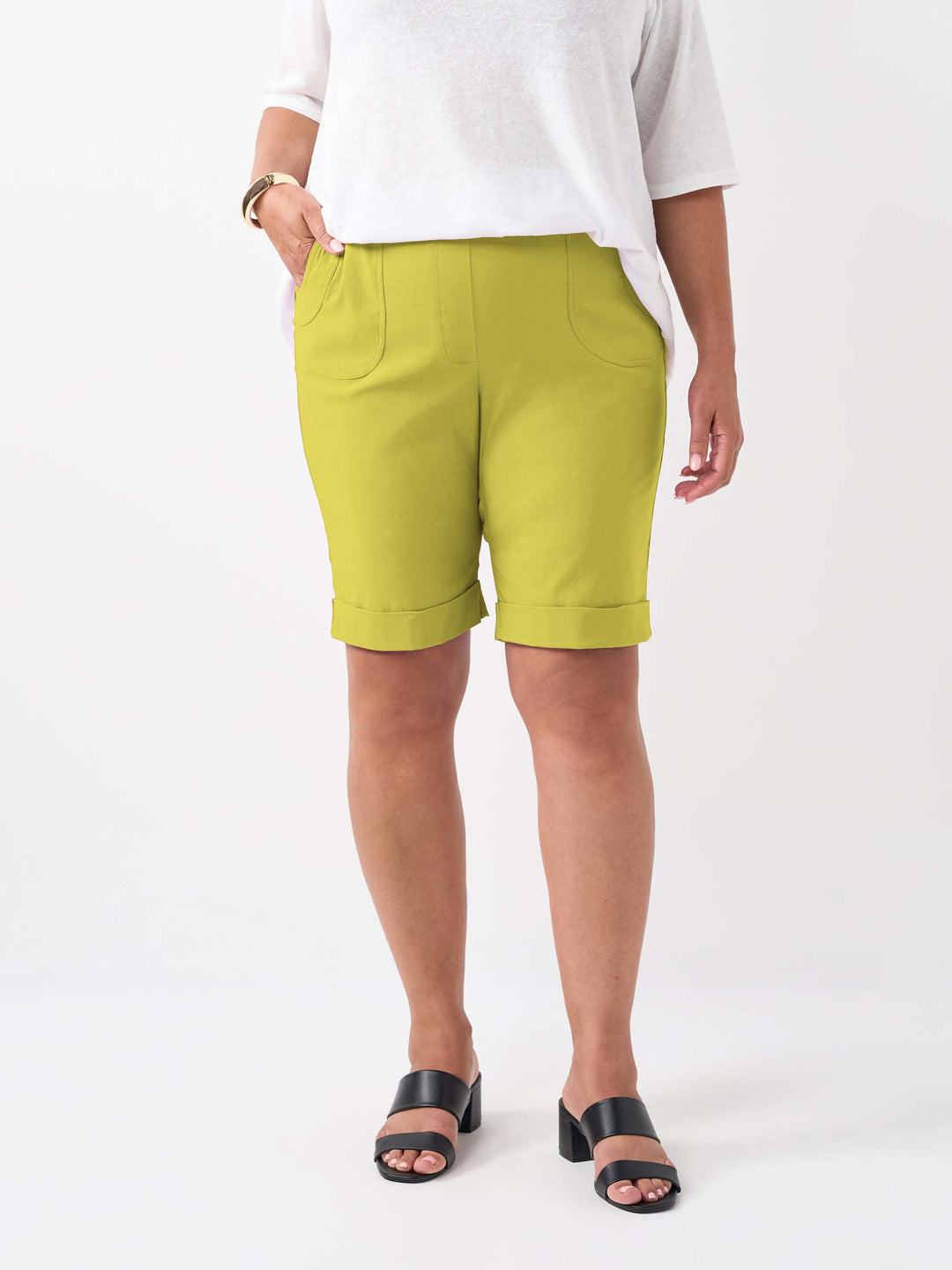A person wearing a plain vibrant citrus knee length bengaline shorts with two pockets