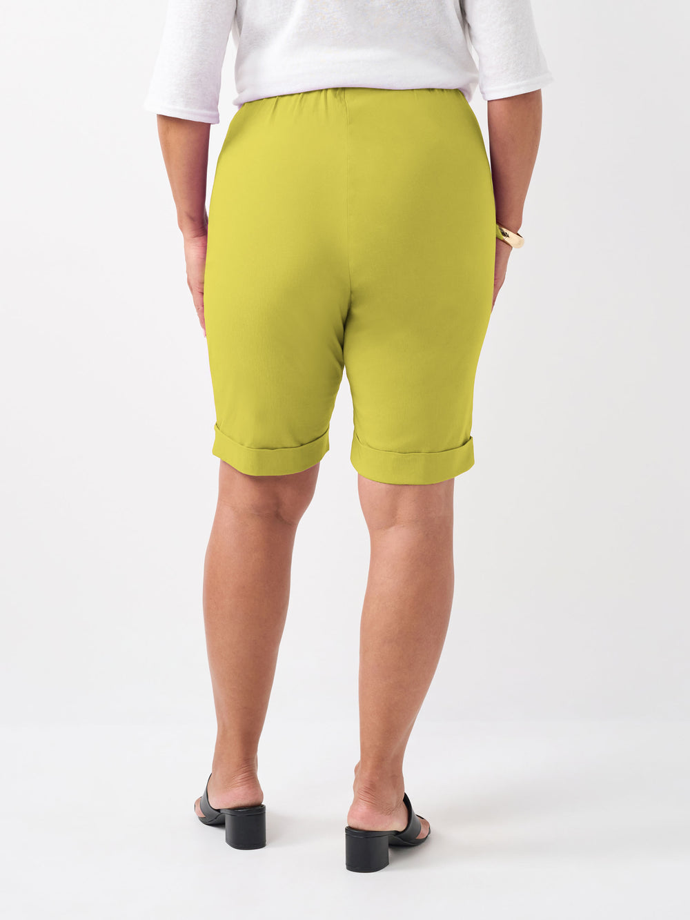 A person wearing a plain vibrant citrus knee length bengaline shorts