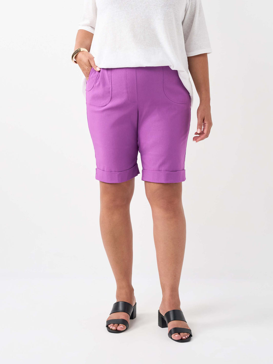 A person wearing a plain orchid purple knee length short with two pockets