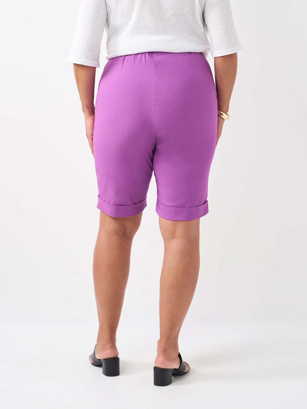 A person wearing a plain orchid purple knee length shorts