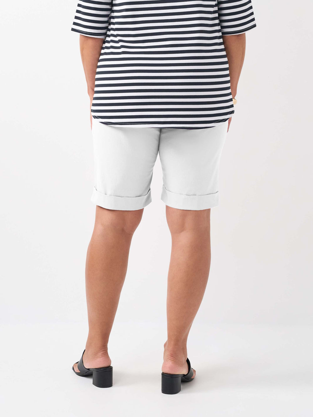 A person wearing a plain white knee length bengaline shorts