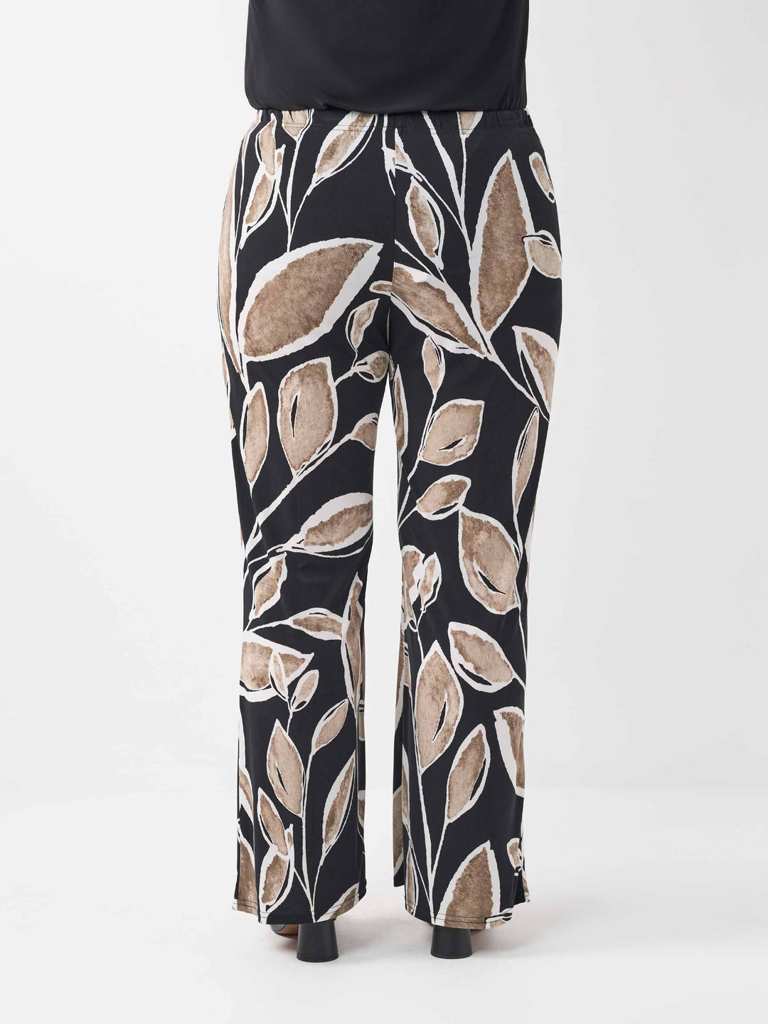 back view of a wide-leg palazzo pants with a black base and an abstract leaf pattern in beige and white