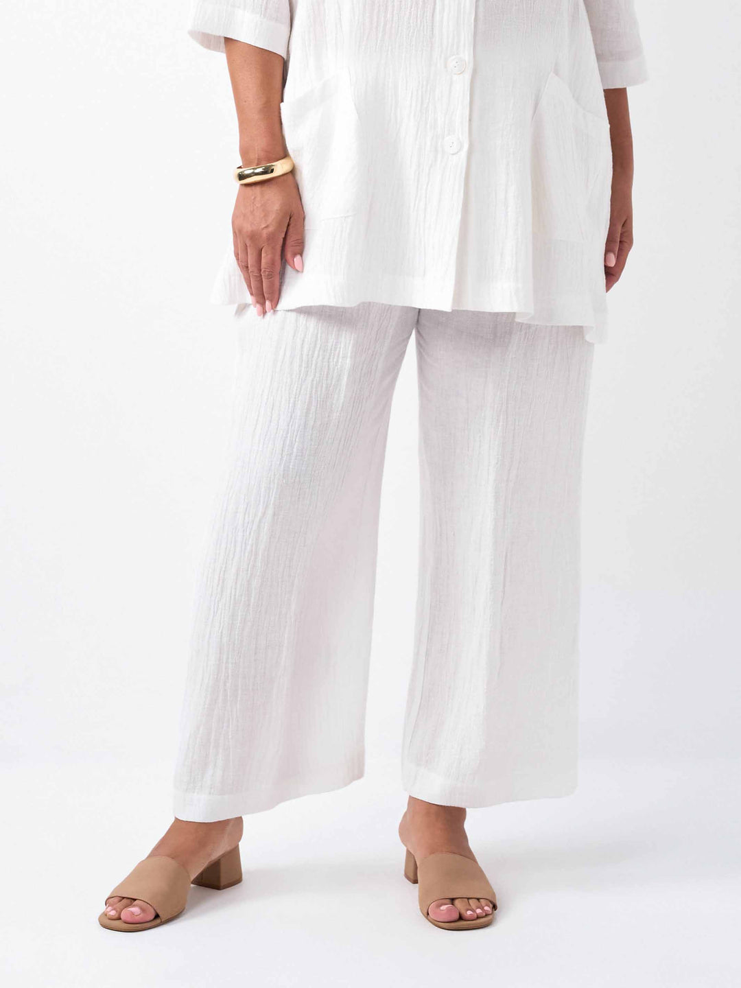 A model wearing a white textured white wide-leg cropped pants, paired with the matching top