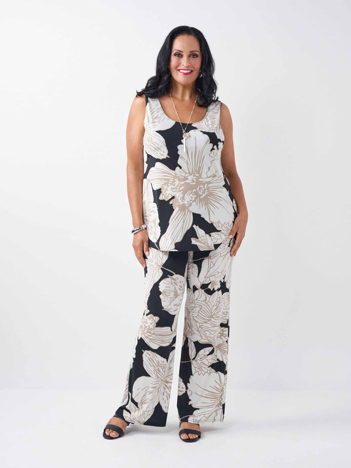 model wearing a cami and matching wide-leg palazzo pants featuring a bold beige floral pattern on black base