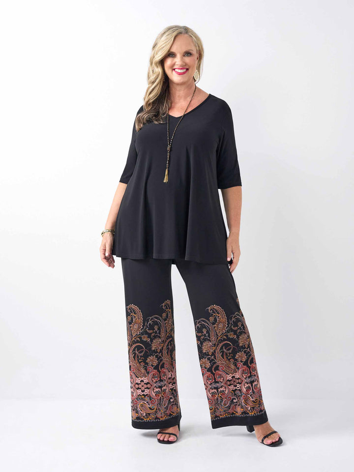 a woman wearing a v-neck swing top styled with a pair of stylish palazzo pant with stylish boho inspired print