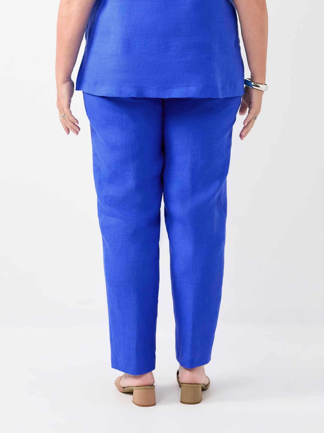 A person shown from the back wearing bright cobalt blue pants and a matching cami