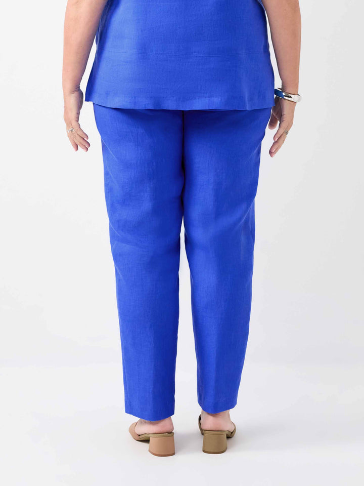 A person shown from the back wearing bright cobalt blue pants and a matching cami