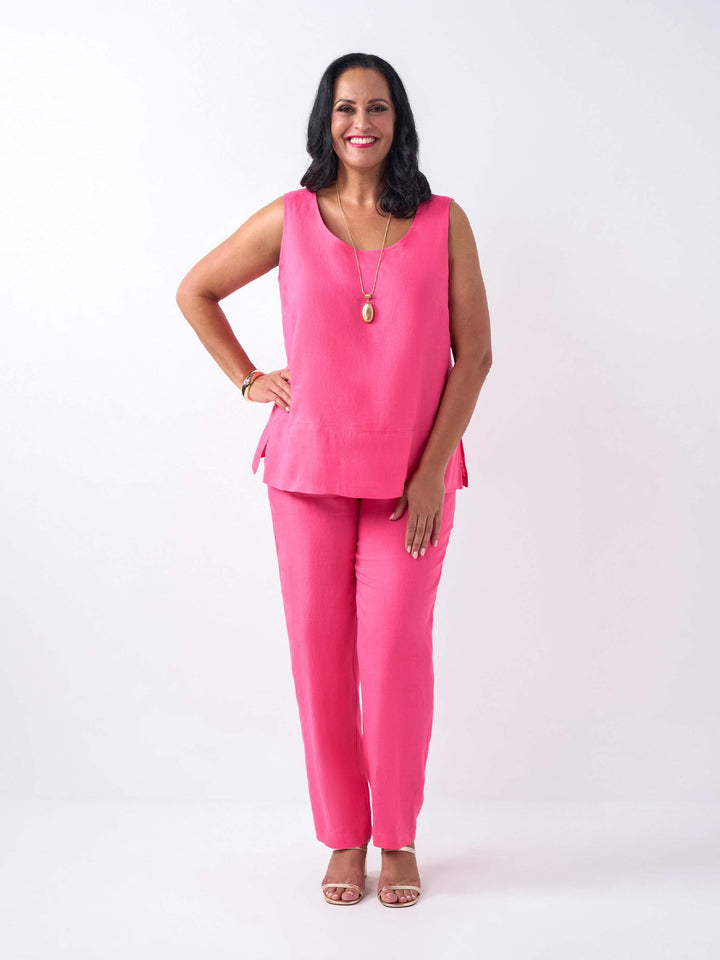 a woman wearing a plain linen cami in bright pink, paired with matching full length straight leg pant