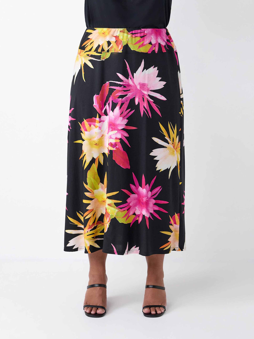 A black midi skirt with a vibrant, large-scale tropical floral print in pink and yellow