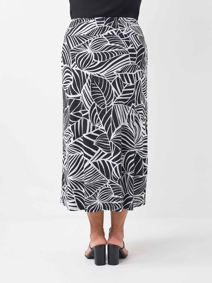 back view of a black v-neck top paired with a black and white tropical leaf printed skirt