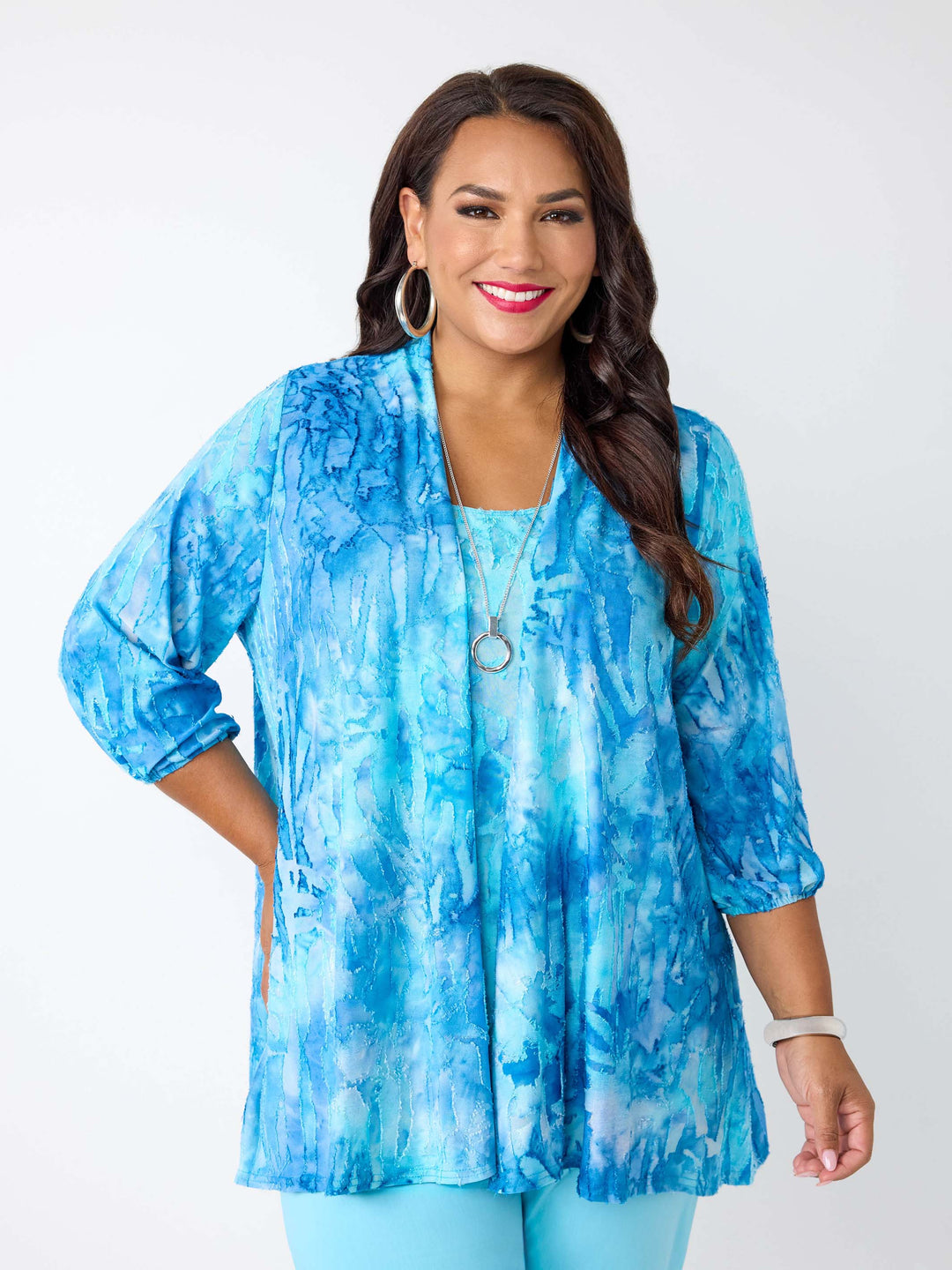 A woman wearing a blue tie-dye burnout jacket and cami set with three-quarter sleeves
