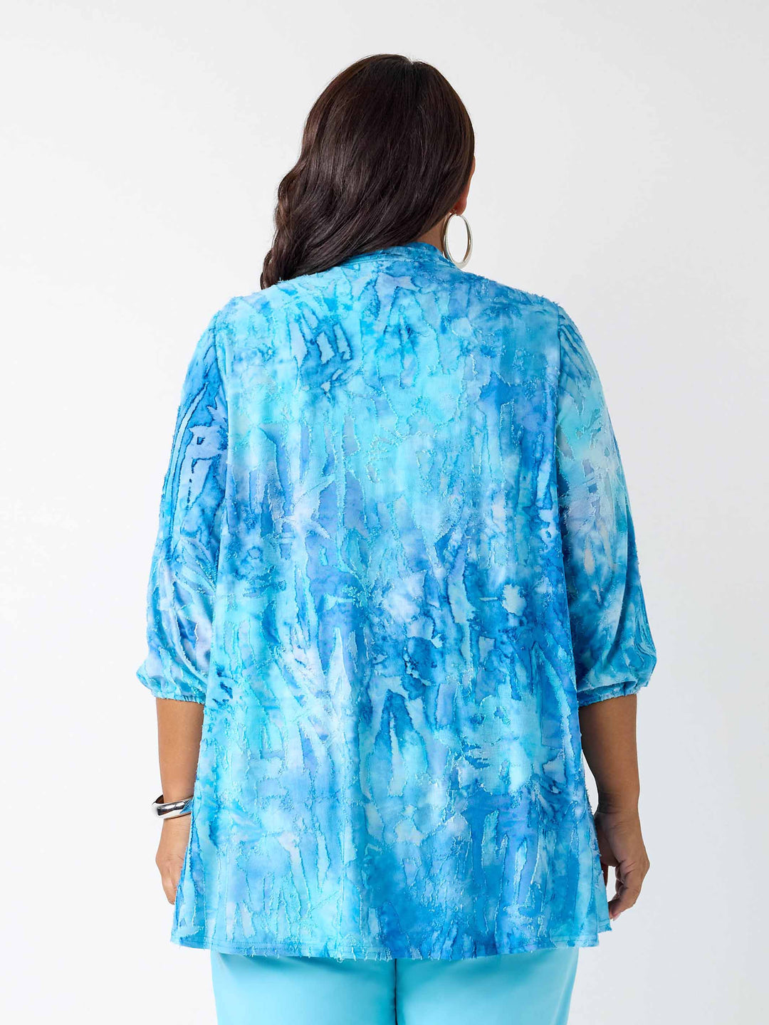 A woman viewed from the back wearing a blue dye jacket with three-quarter sleeves