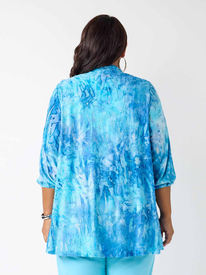 A woman viewed from the back wearing a blue dye jacket with three-quarter sleeves