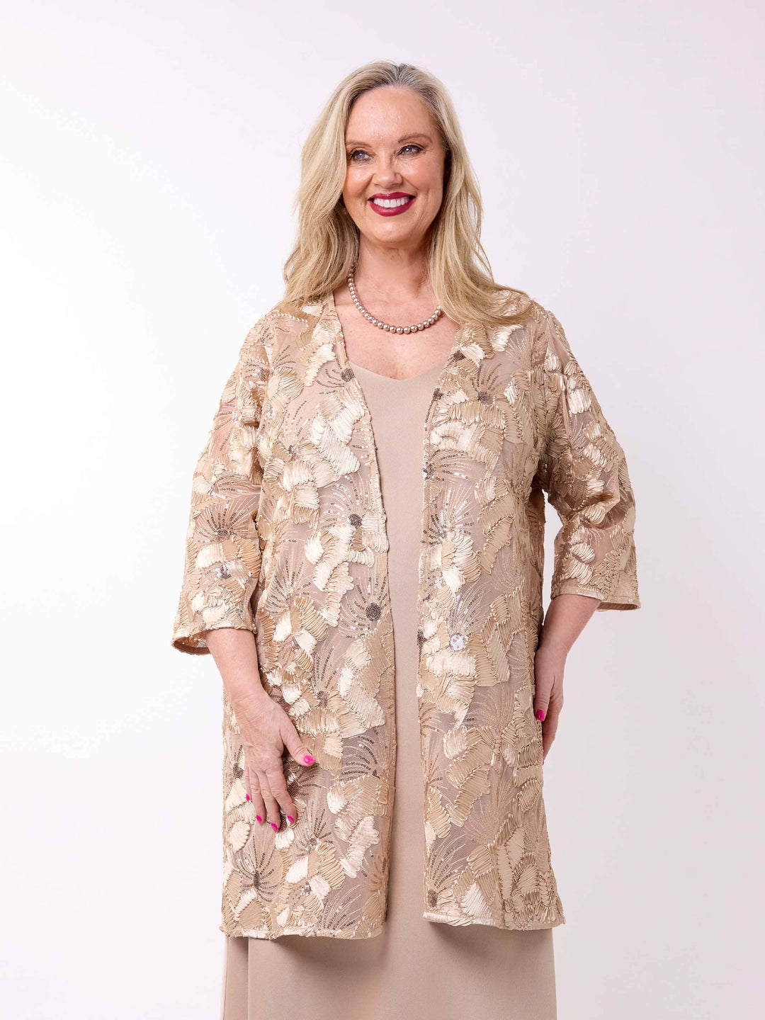 a woman wearing a sheer longline evening jacket which sequin embroidered detail styled with a champagne dress