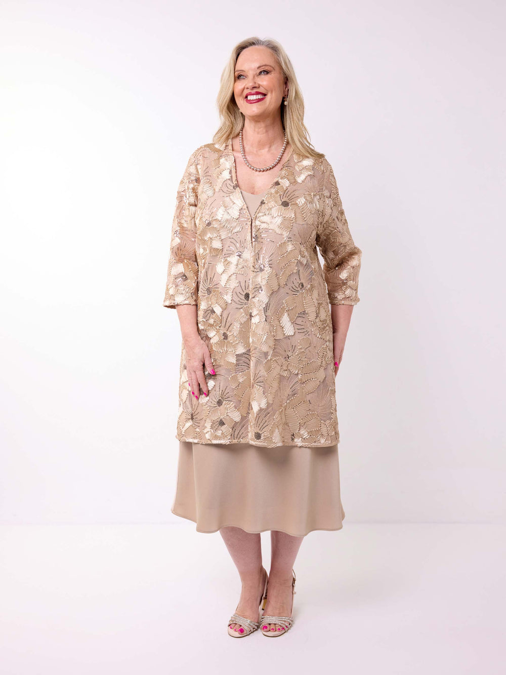 a woman wearing a sheer longline evening jacket which sequin embroidered detail styled with a champagne dress