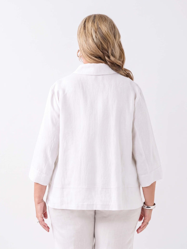 A woman wearing a white short-sleeve button-front collared jacket