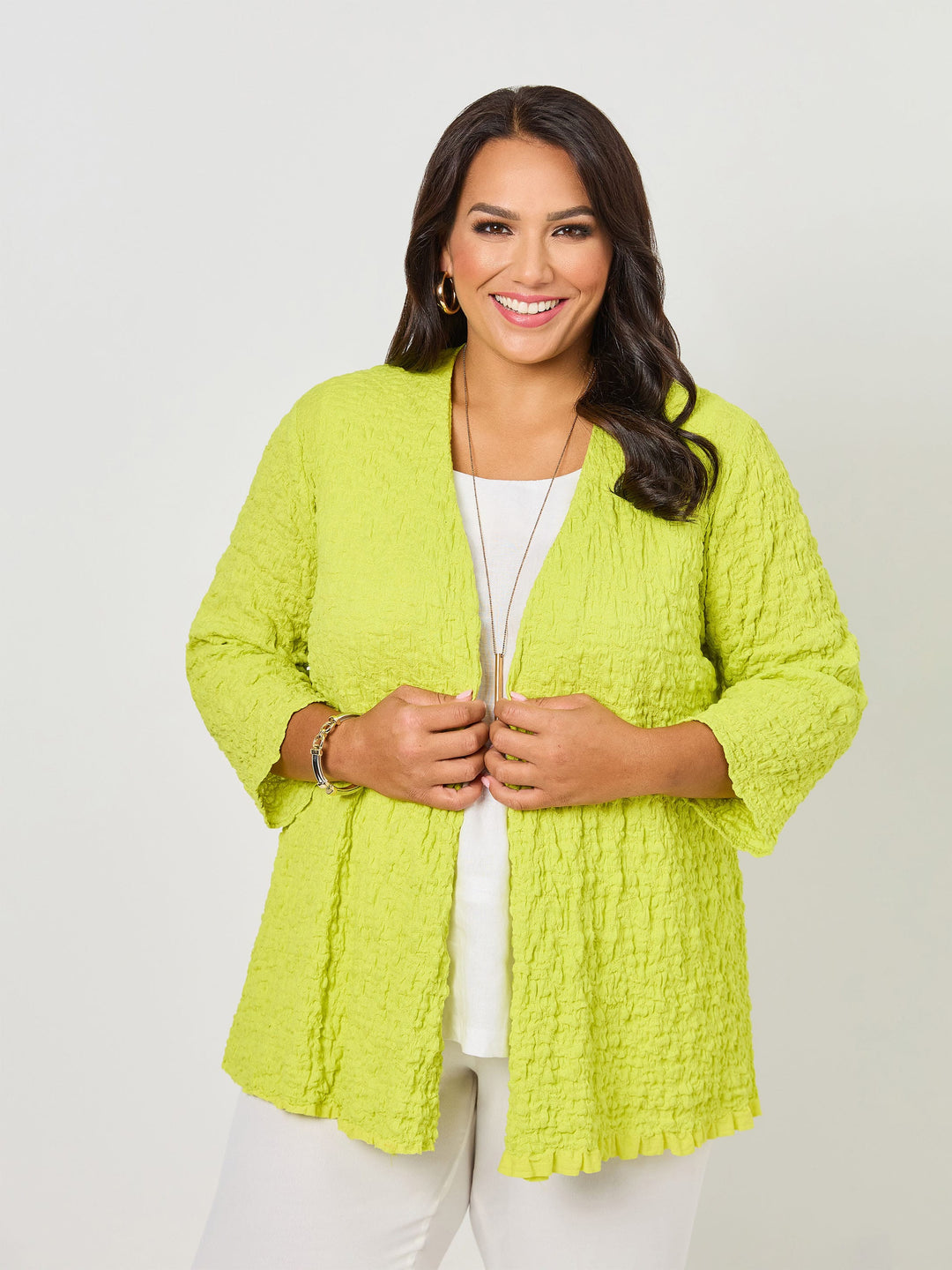 A woman wearing a vibrant fresh lime yellow textured open front cardigan