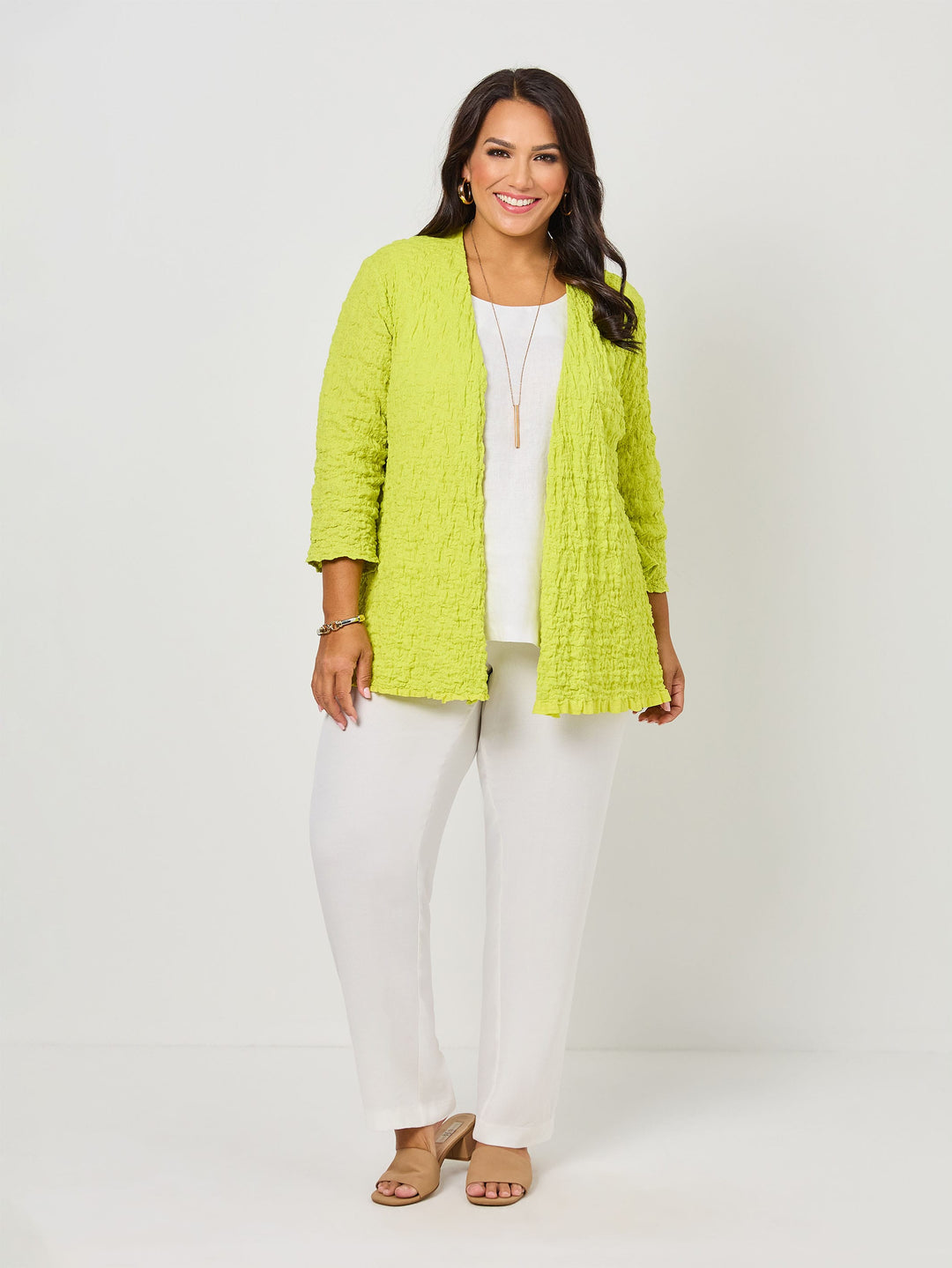 A woman wearing a vibrant fresh lime yellow textured open front cardigan