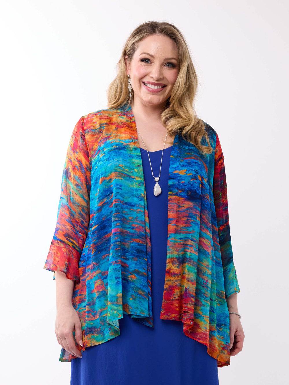 A woman wearing a colourful abstract-print frill sleeves georgette jacket over a royal blue dress