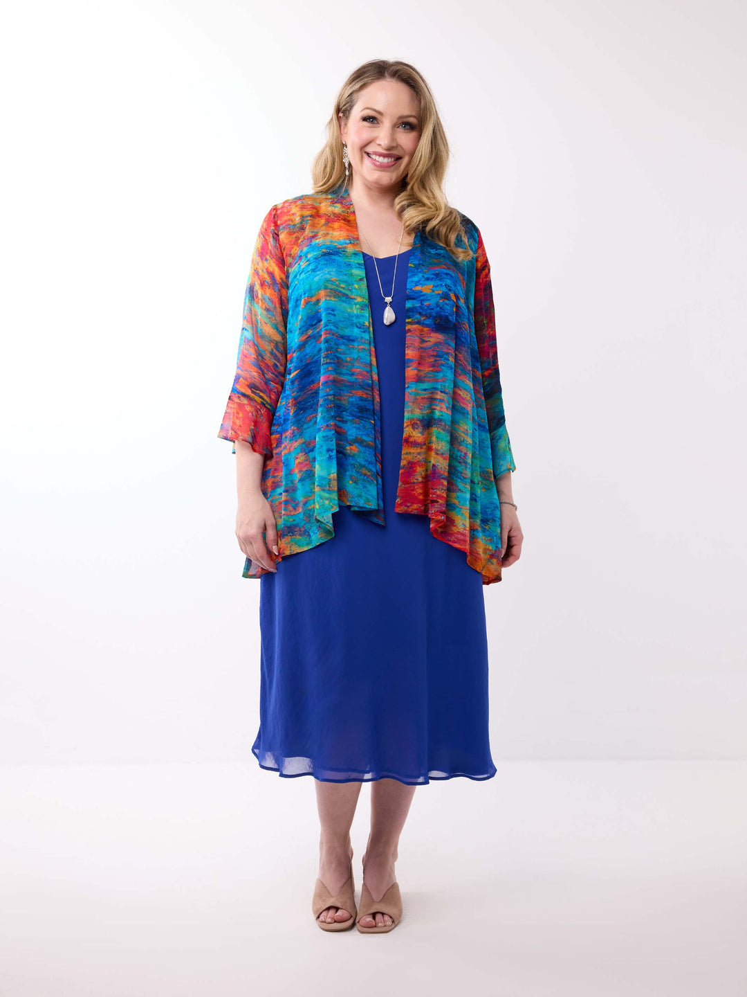 A woman wearing a colourful abstract-print frill sleeves georgette jacket over a royal blue dress