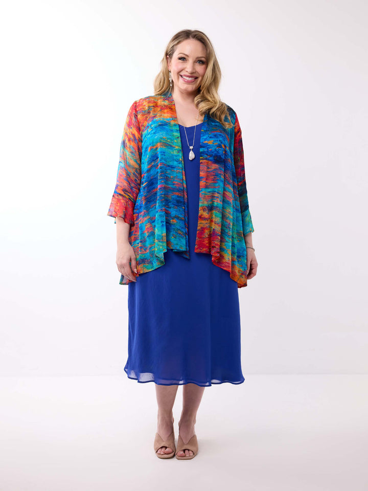 A woman wearing a colourful abstract-print frill sleeves georgette jacket over a royal blue dress