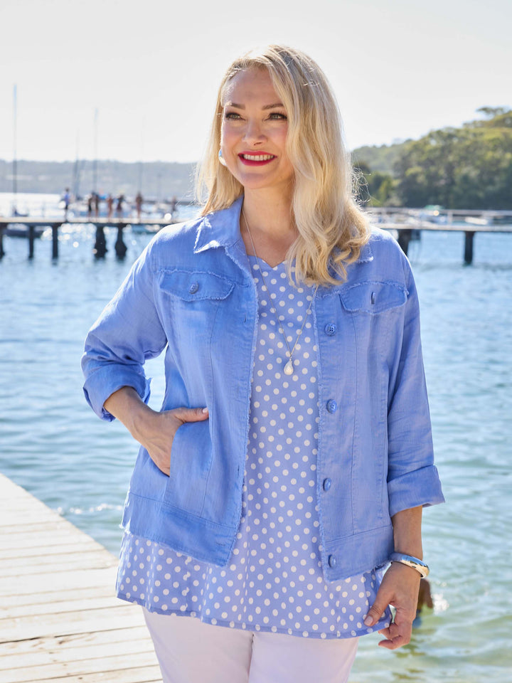 A woman wearing a light blue denim-style linen jacket