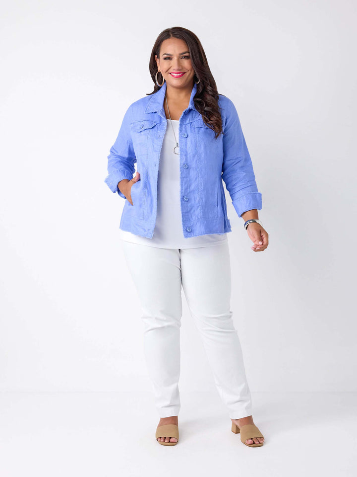 A woman wearing a light blue cropped linen denim style jacket over a white top