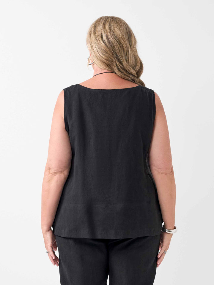 A woman viewed from the back wearing a sleeveless black top and black pants