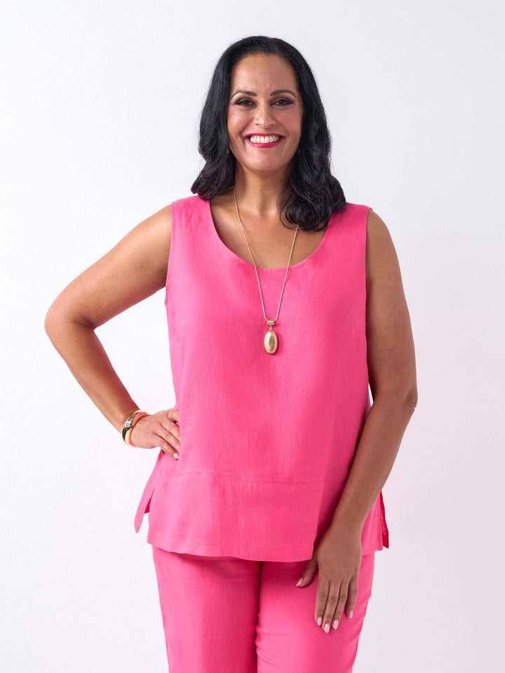 A woman wearing a bright pink sleeveless linen top and matching pink pants