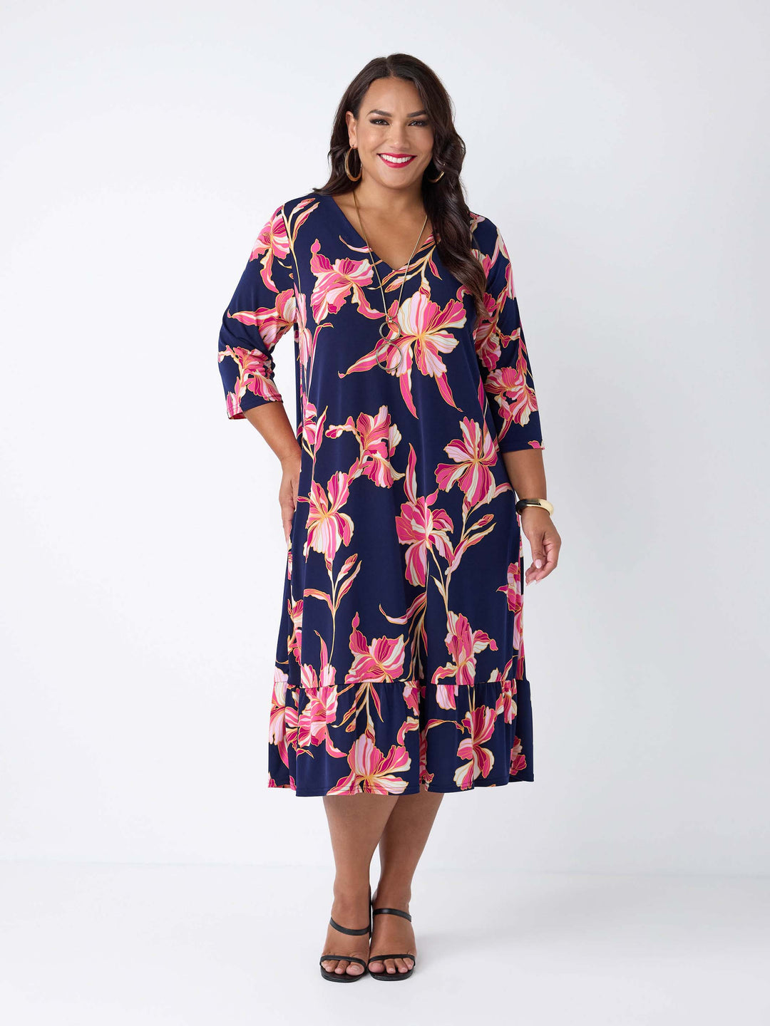 model wearing a navy blue midi dress with a pink floral print, featuring a V-neckline, three-quarter sleeves, and frill hemline