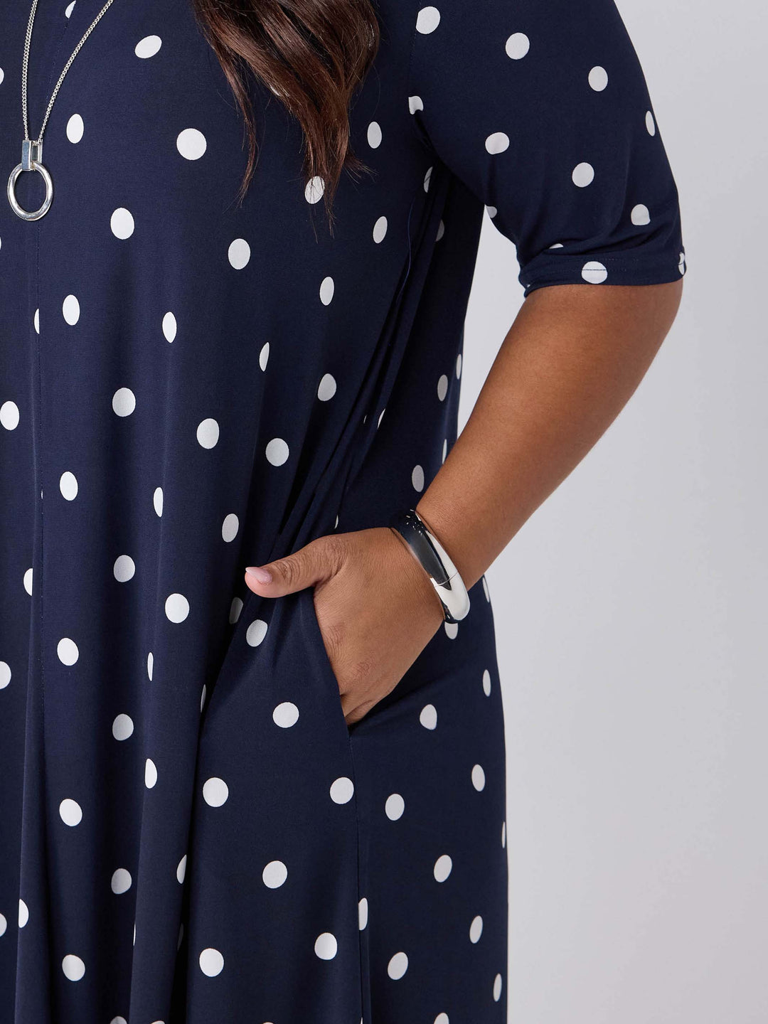 detail view of a navy and white polka dot dress with side pockets