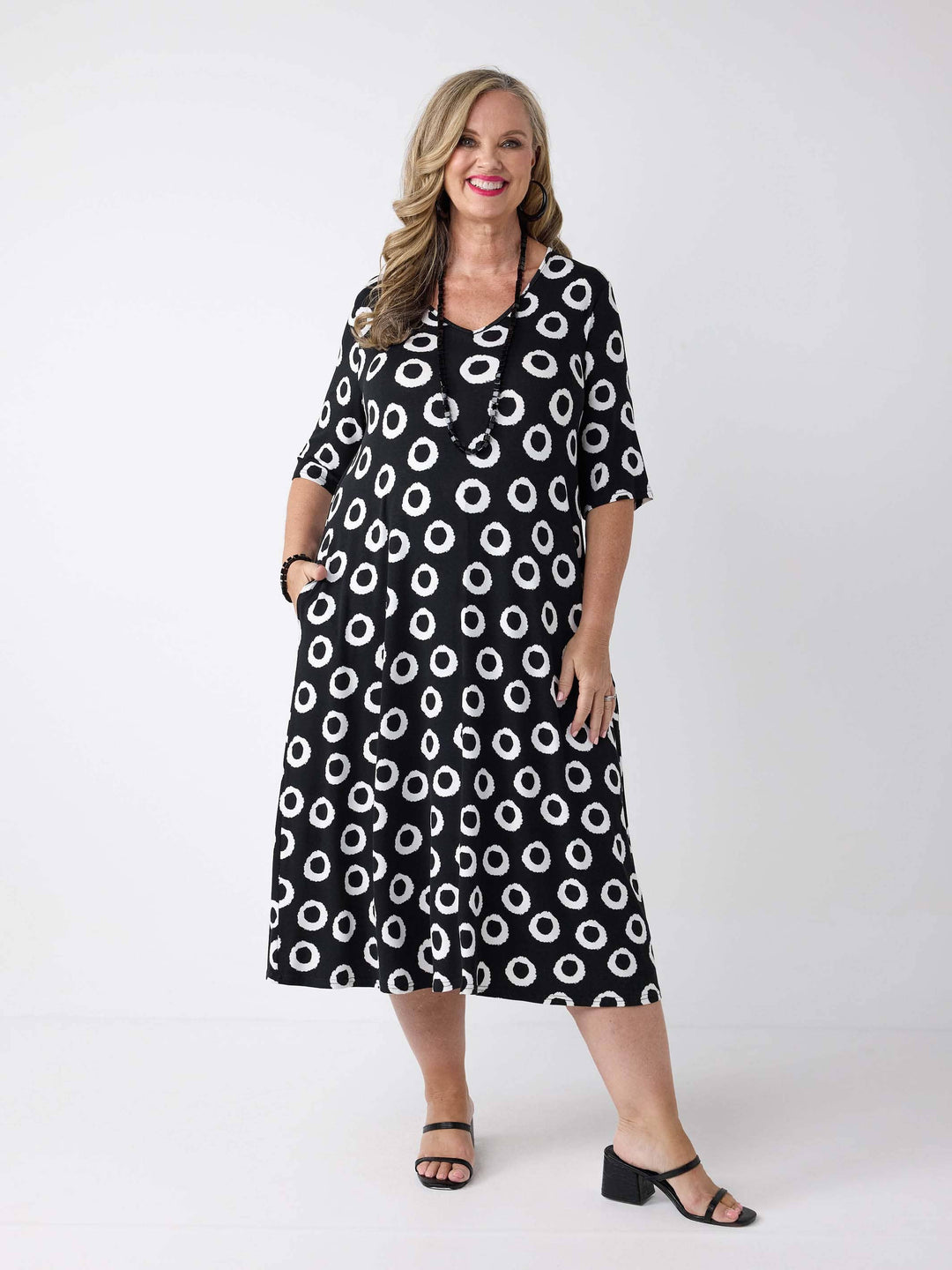 a woman wearing a v-neck midi dress in black and white print