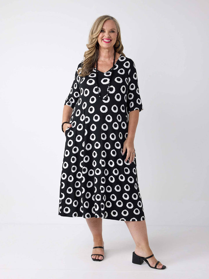 a woman wearing a v-neck midi dress in black and white print