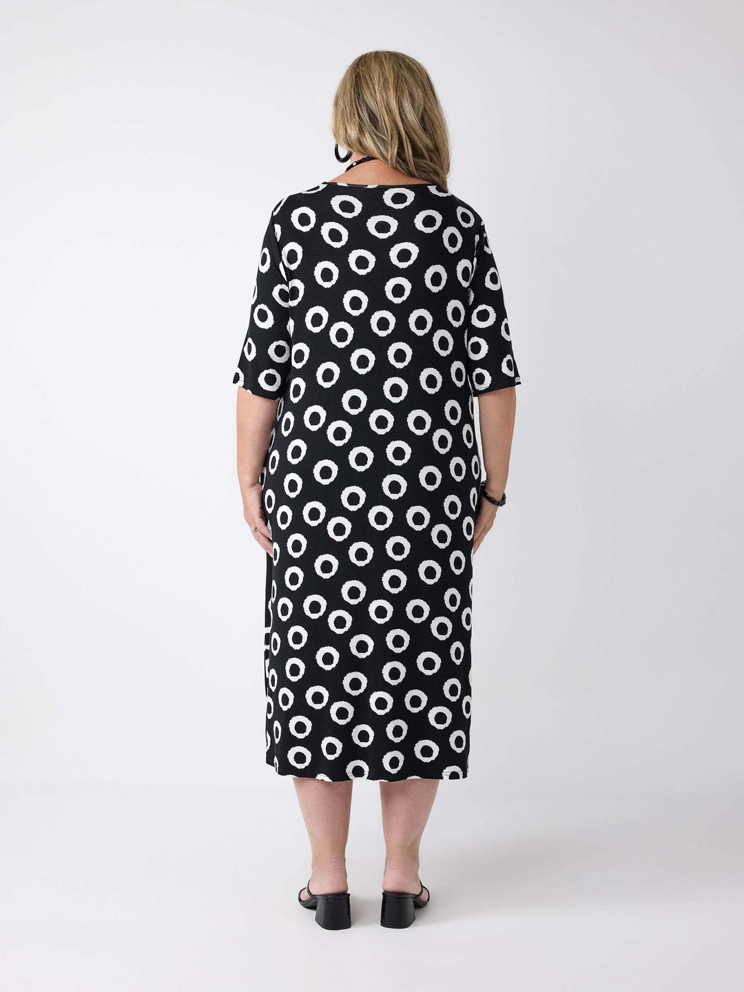 a woman wearing a v-neck midi dress in black and white print