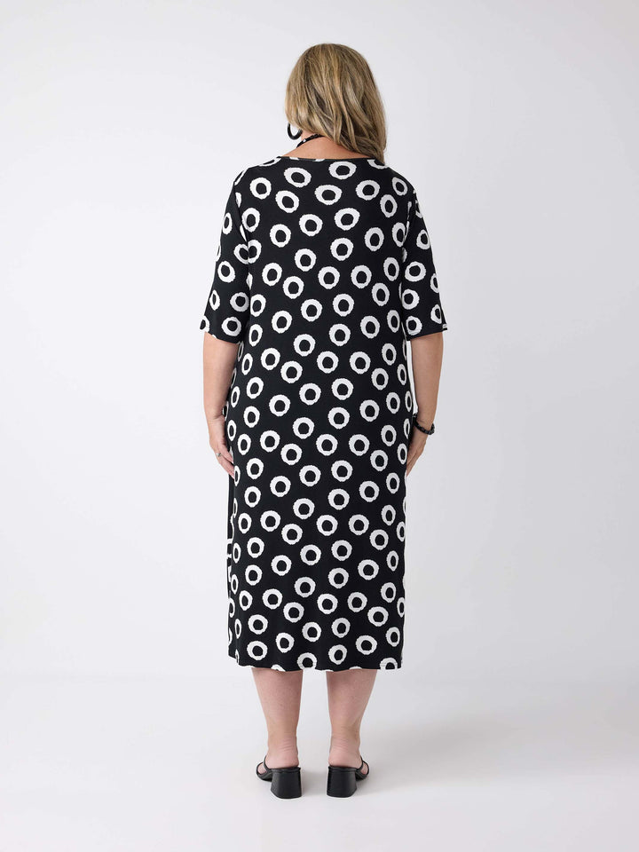 a woman wearing a v-neck midi dress in black and white print