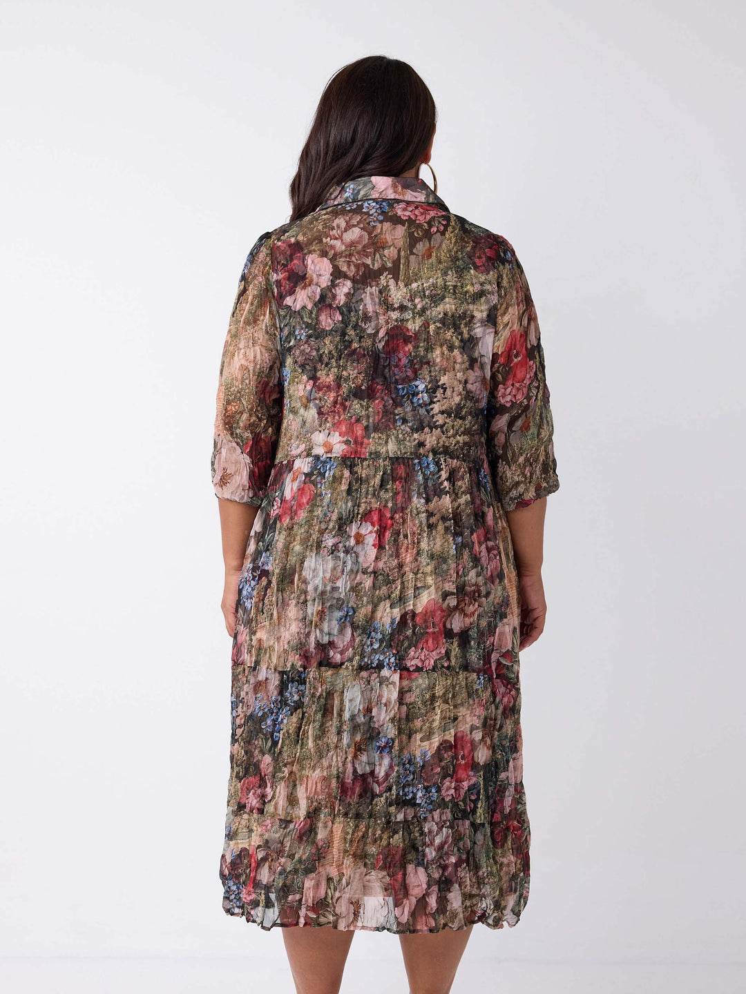 A woman viewed from the back wearing a collared crushed georgette midi shirt dress with garden floral print. 