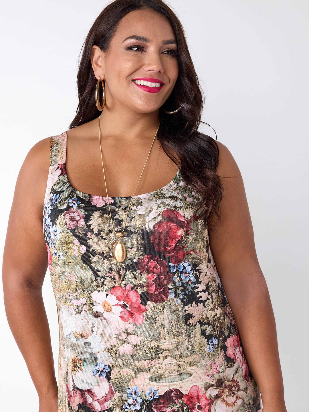 A woman wearing a round neck midi under layered dress with garden floral print. 