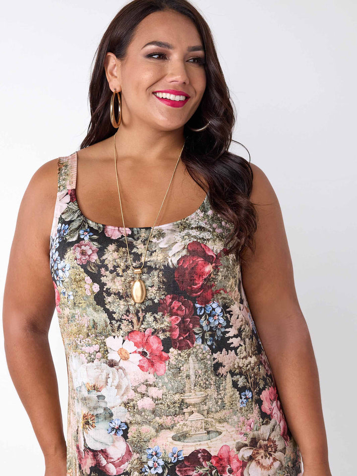 A woman wearing a round neck midi under layered dress with garden floral print. 