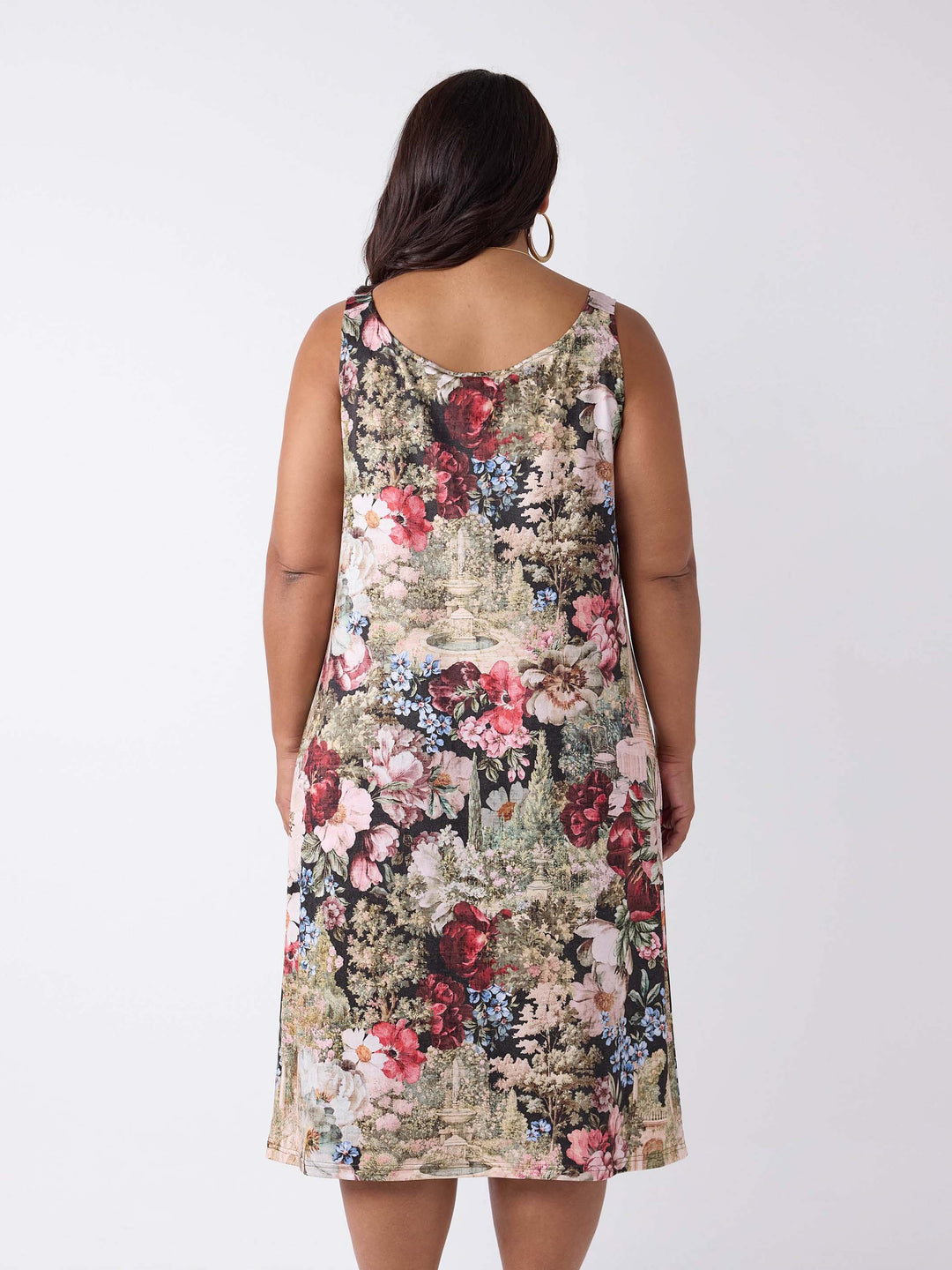 A woman wearing a round neck midi under layered dress with garden floral print. 