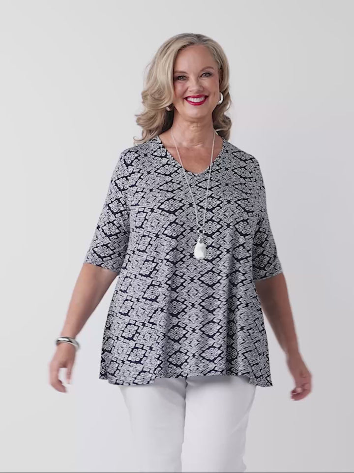 video of model wearing a navy v-neck swing jersey top with white print