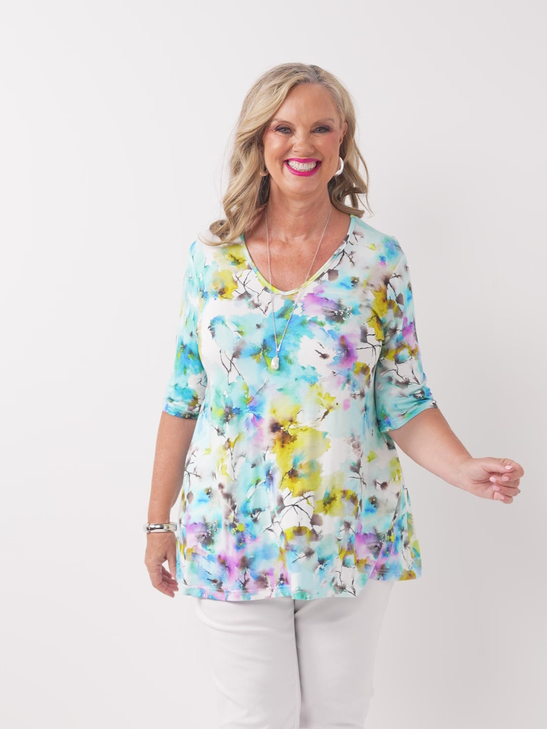 A video of a woman wearing a short-sleeve jersey top with a vibrant blue watercolour floral print
