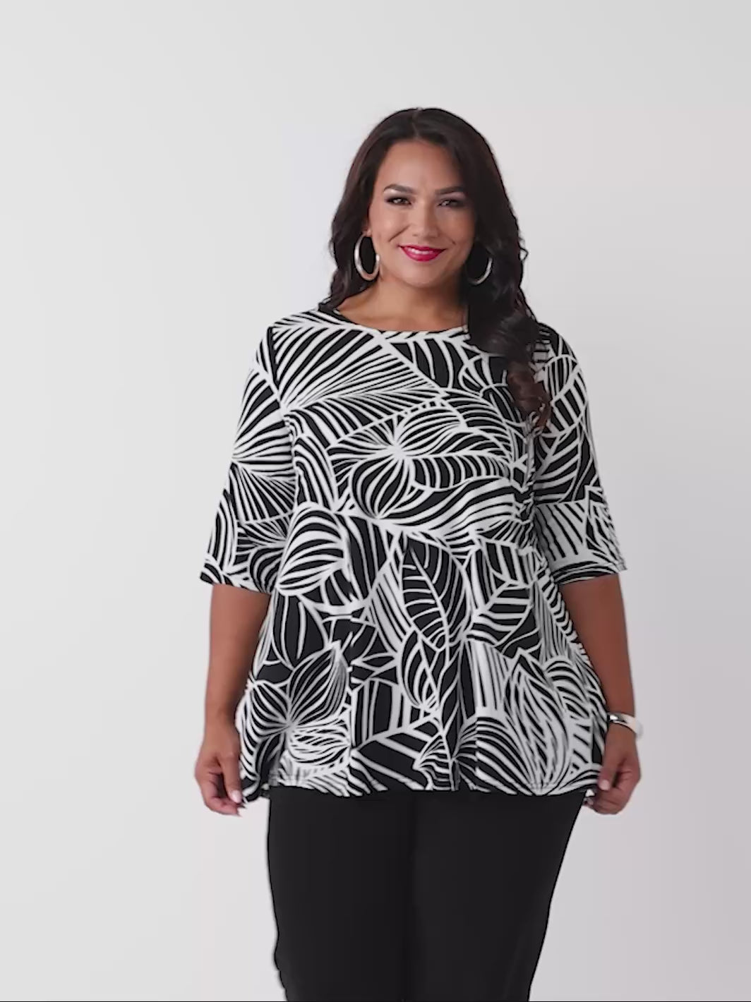 video of model wearing a black and white tropical leaf print three-quarter length sleeve top paired with black palazzo jersey pant