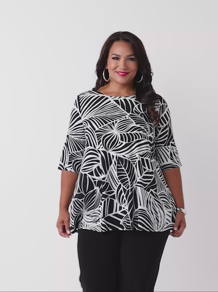 video of model wearing a black and white tropical leaf print three-quarter length sleeve top paired with black palazzo jersey pant