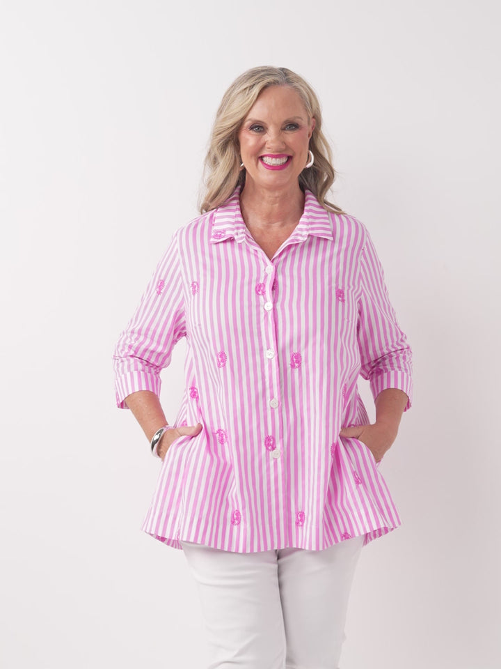 A video of a woman wearing a pink and white striped button-up collared cotton shirt with embroidered pink paisley details