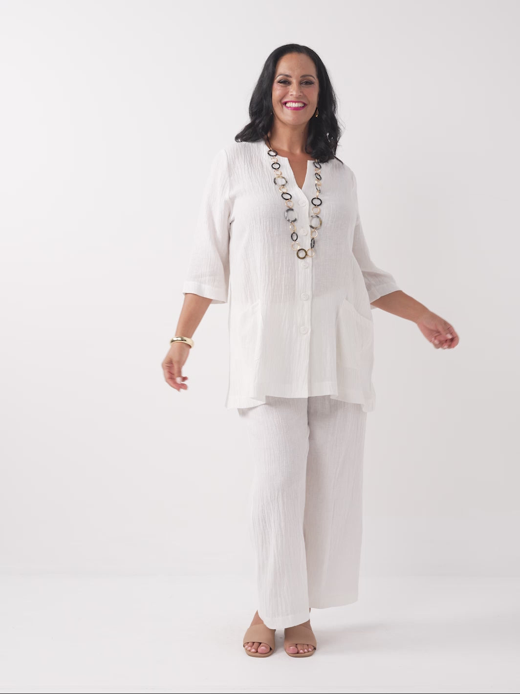 A model wearing a white textured white wide-leg cropped pants, paired with the matching top