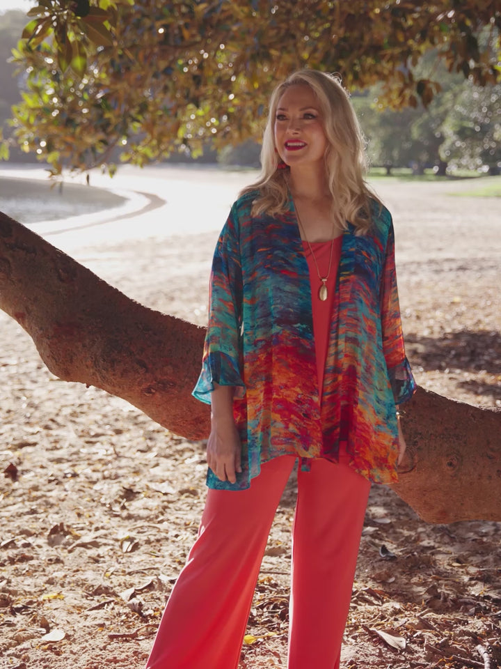 A woman wearing a colourful abstract-print frill sleeves georgette jacket over a royal blue dress