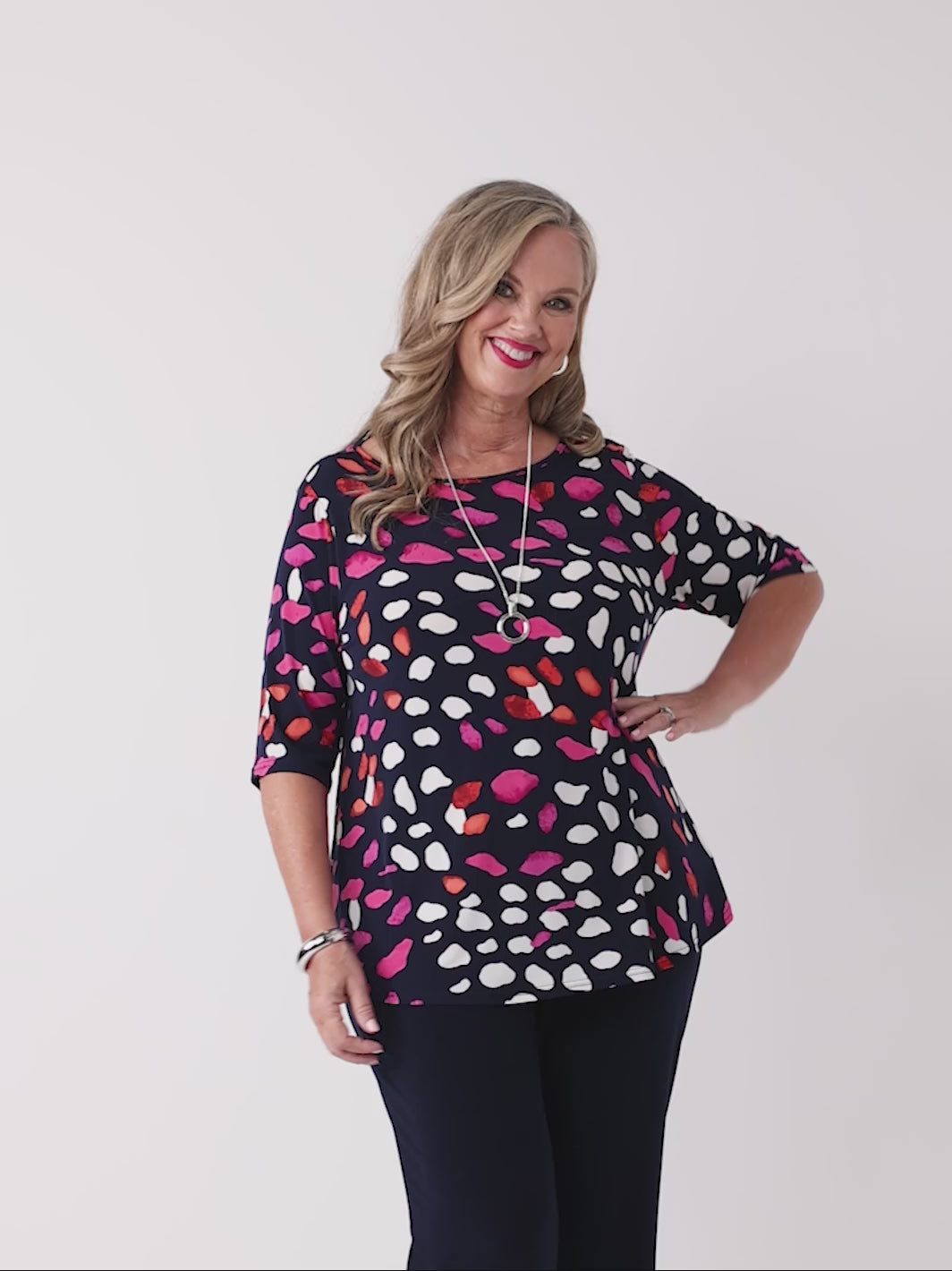 video of model wearing a navy blue jersey top with colourful pebble print in pink and white