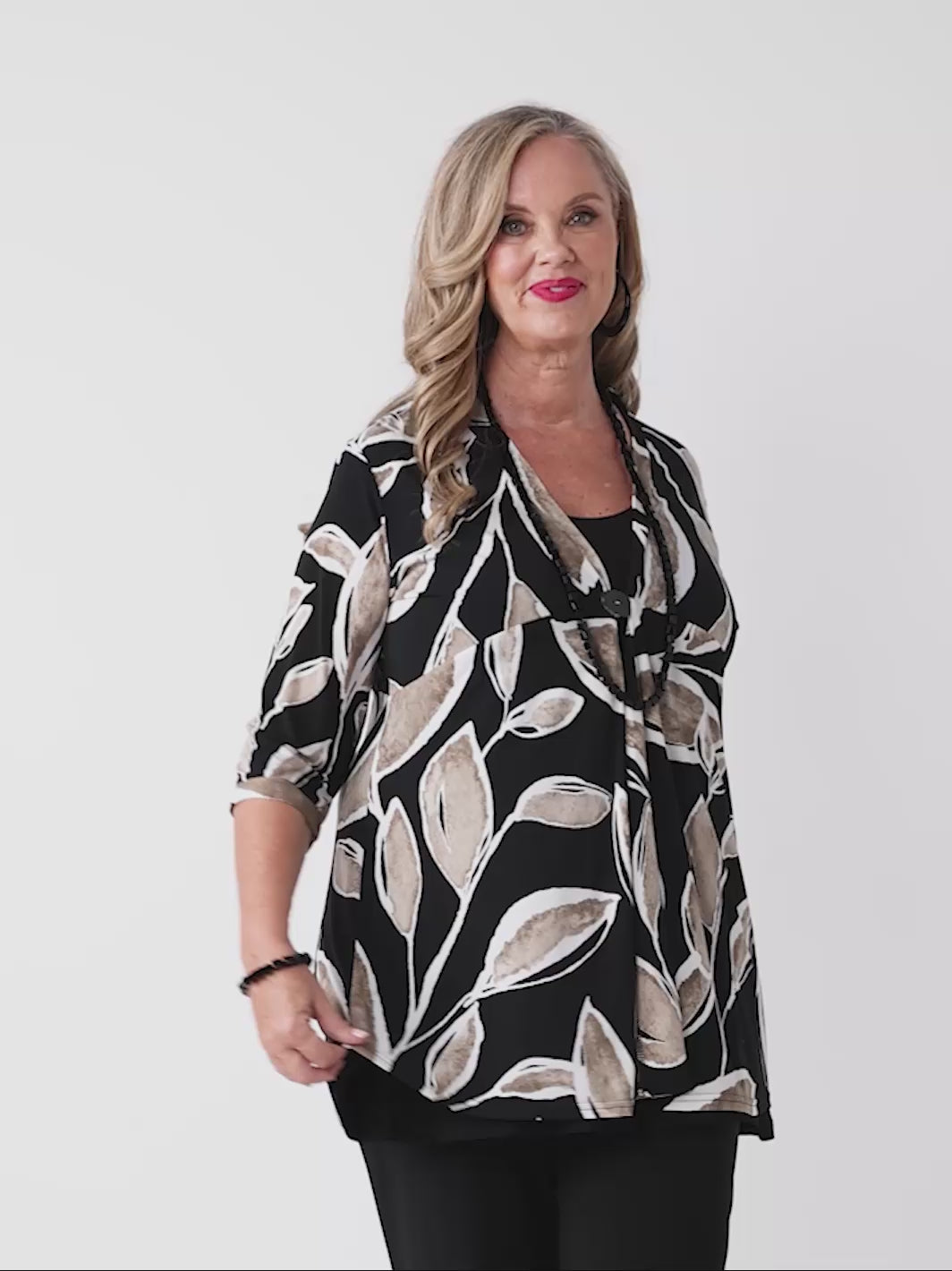 video of woman wearing a black three-quarter sleeve lightweight jacket with a beige and white leaf pattern